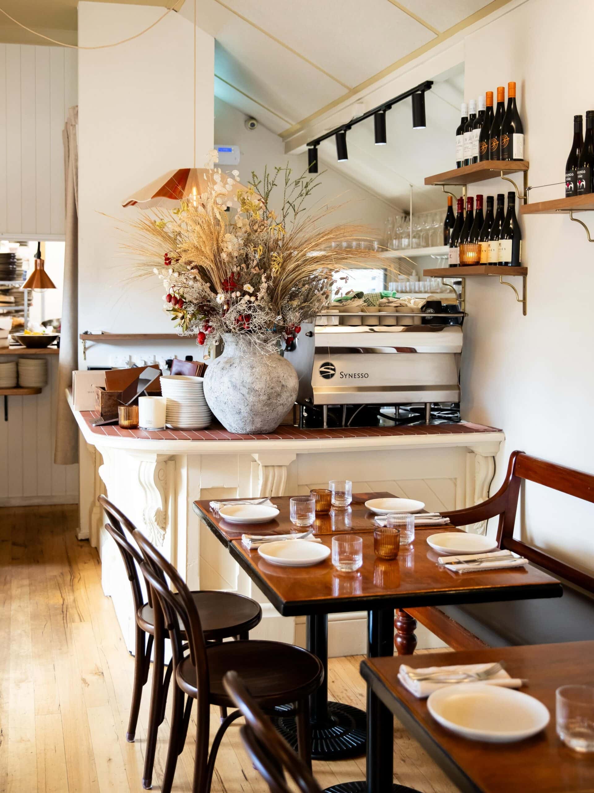 Interior of Tommy Gunn’s in Barwon Heads, with timber tables, bentwood chairs, wine shelves and a bright coastal dining room.