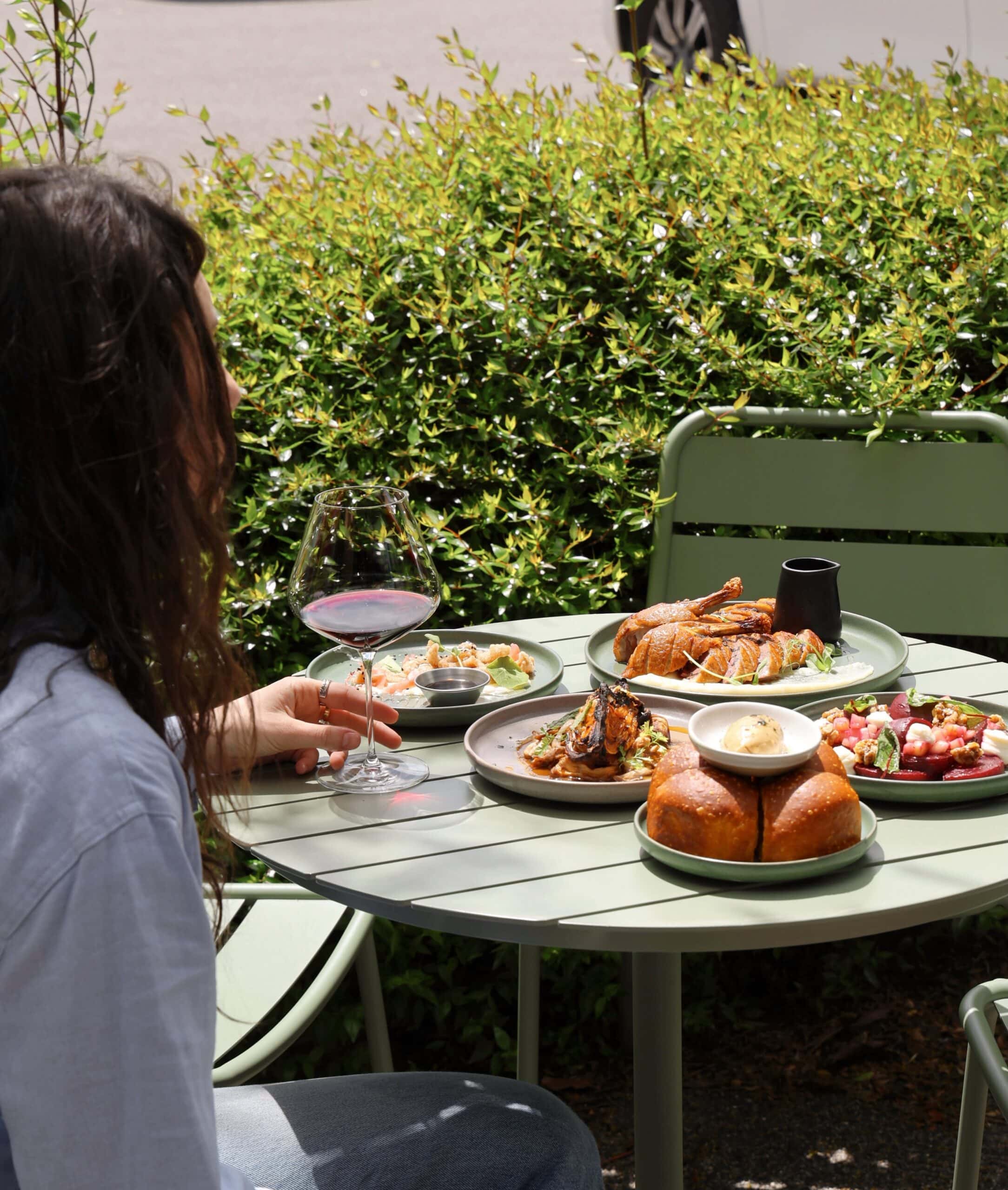 Guest enjoying lunch and red wine in the garden courtyard at Woolstore restaurant in Newtown, Geelong.