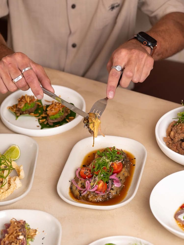 A man tucking into a spread of Asian fusion dishes from Wildginger in Huskisson.