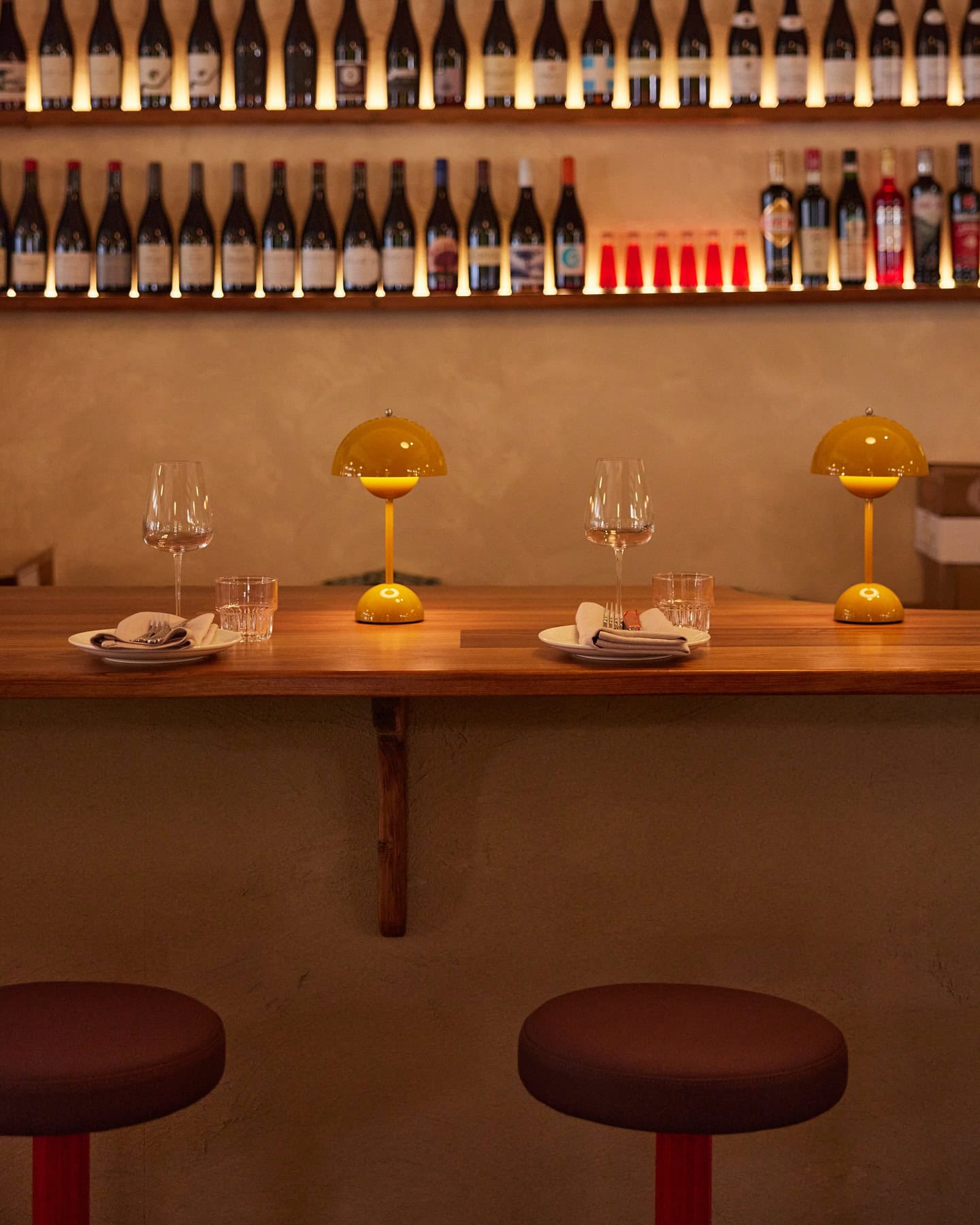 The bar seating at Longplay Bistro in Adelaide with a shelve of wine sitting above it.