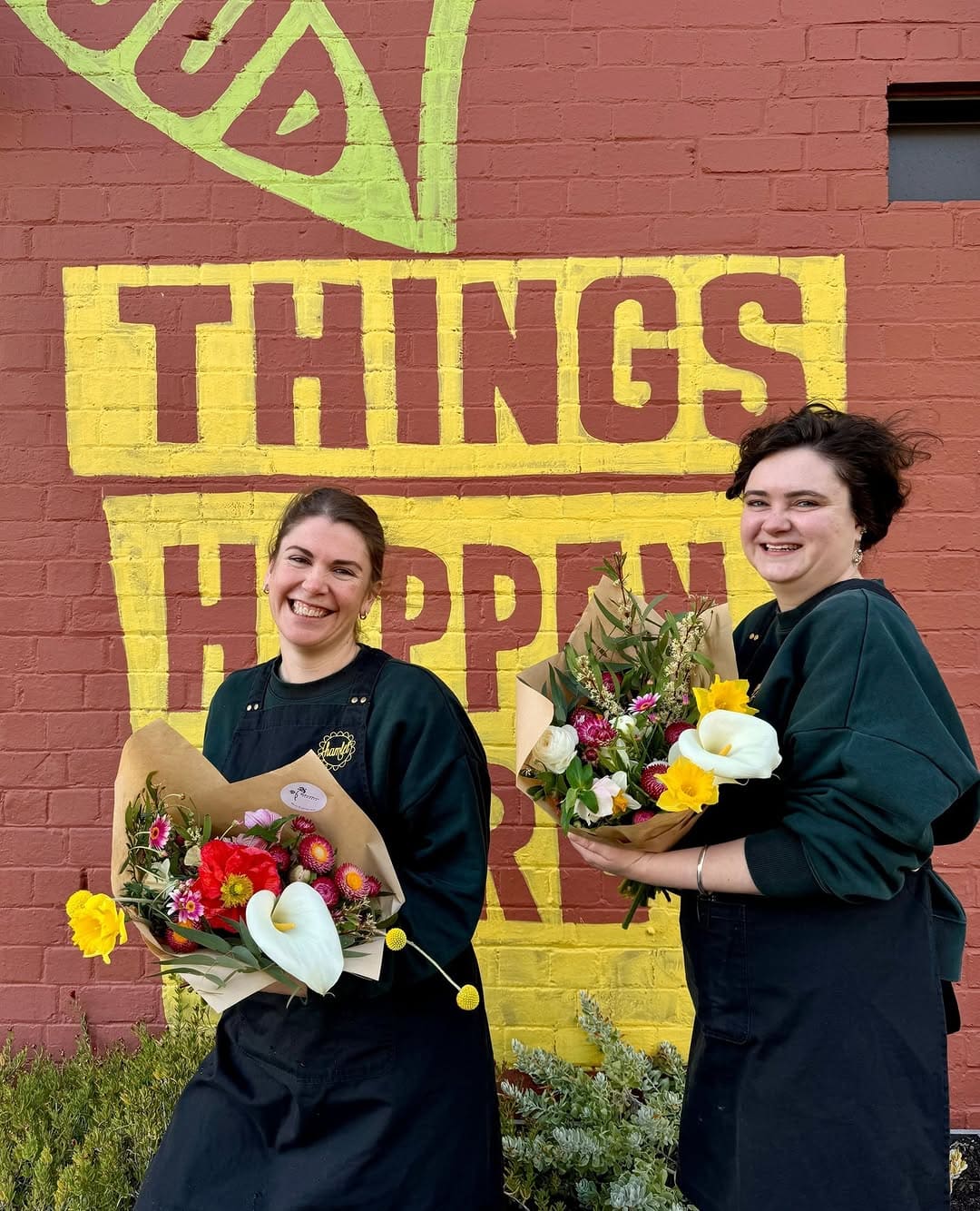 Colleagues holding bouquets in front of Hamlet cafe in Hobart