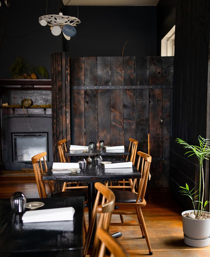 Kadota restaurant interior in Daylesford featuring dark timber walls, wooden dining chairs and minimalist Japanese-inspired styling.