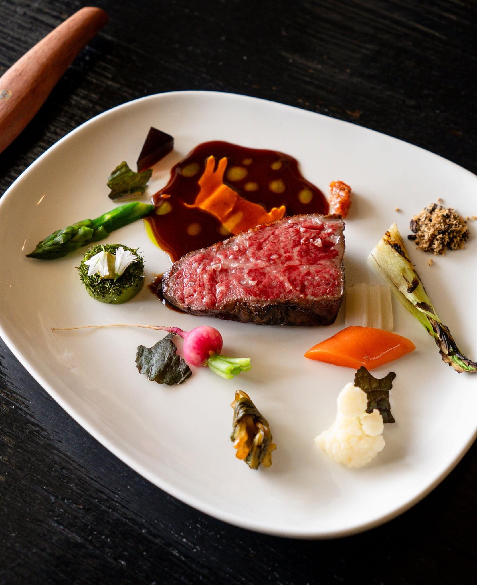 Wagyu beef course with seasonal vegetables, edible flowers and sauce at Kadota restaurant in Daylesford, Victoria.