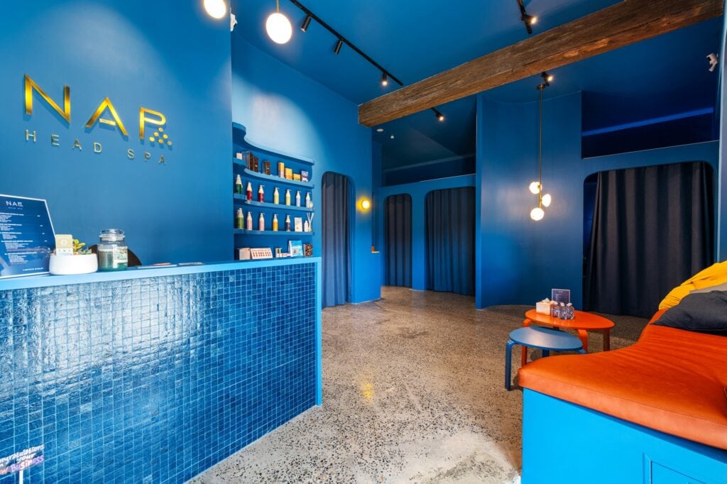 Blue-tiled reception counter and lounge area at NAP Head Spa