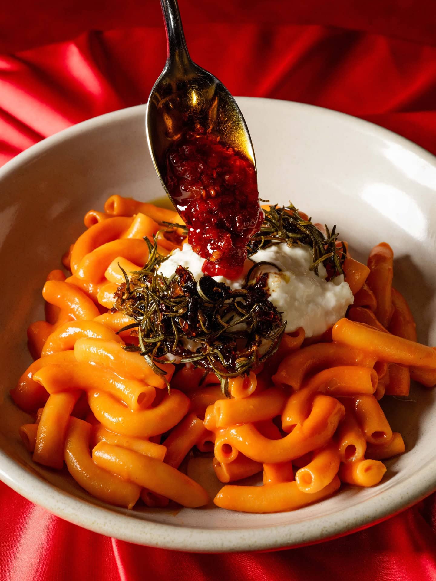 Someone drizzling chilli oil onto a bowl of pasta at Fugazzi Bar & Wine in Adelaide.