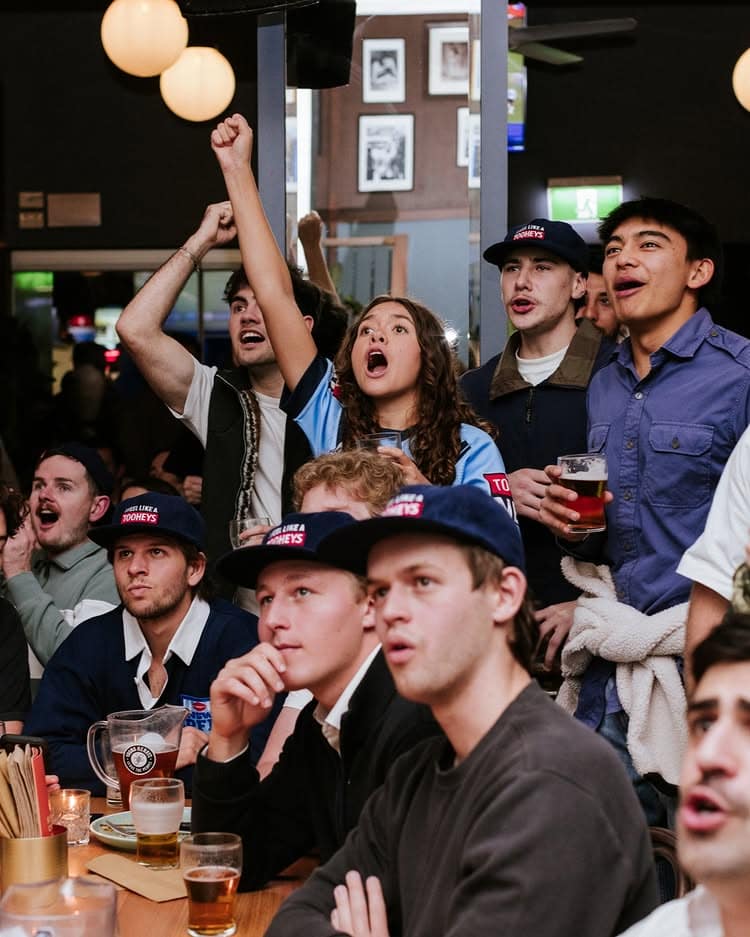 People cheering for a televised sports game at KX Sports Bar Kings Cross.