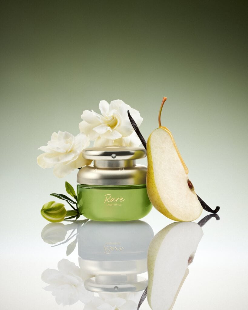 Rare Beauty Rare Beginnings Eau de Parfum bottle styled with pear, gardenia and vanilla pod