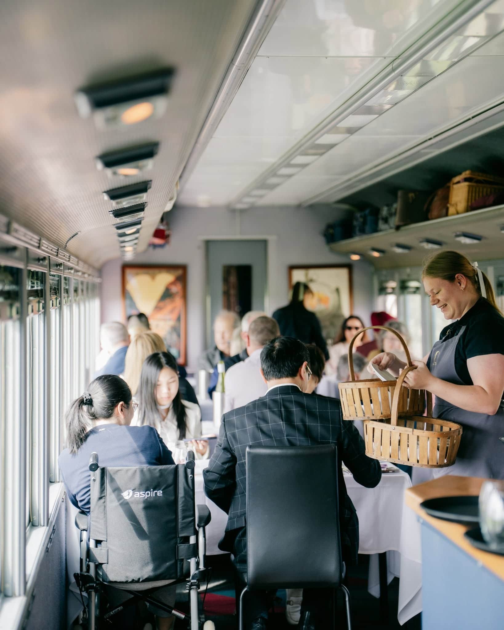 Guests dining aboard The Q Train on the Bellarine Peninsula, with table service inside the restored heritage carriage.