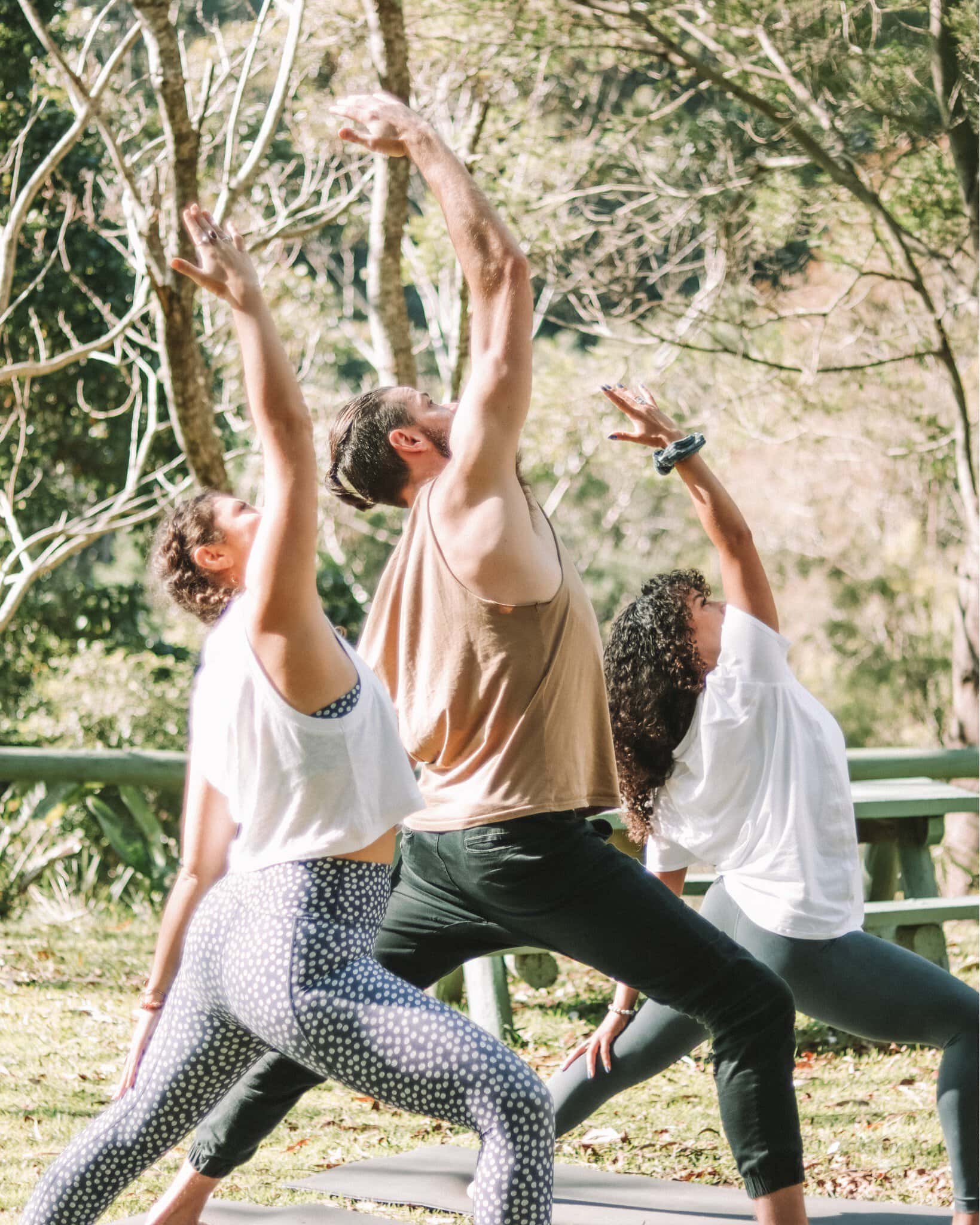 A group of three yogis practicing outdoors at Heart & Soul Retreat in Otford.