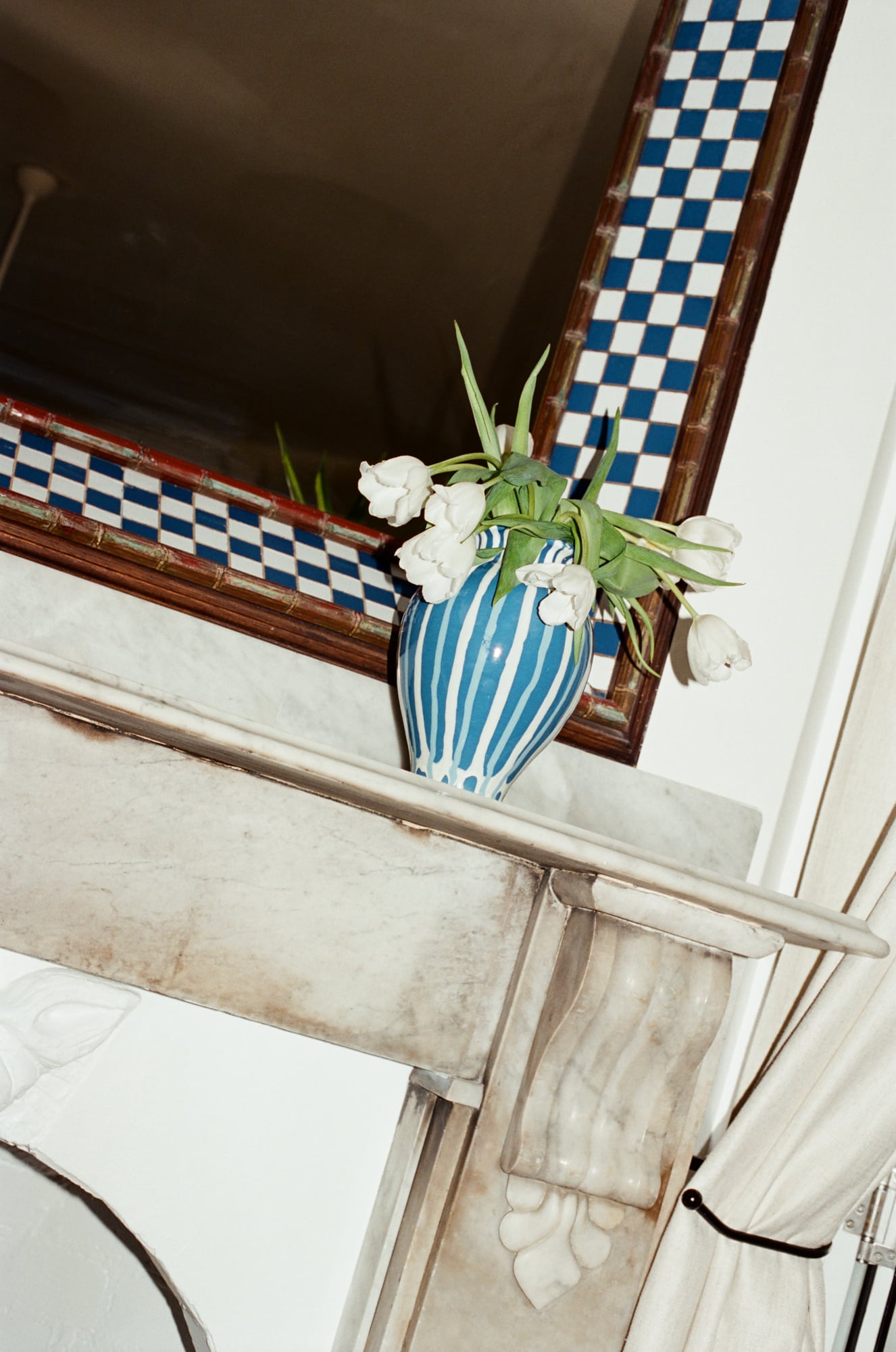 Blue striped Alex and Trahanas x Raes Figura vase with white tulips on a marble mantelpiece