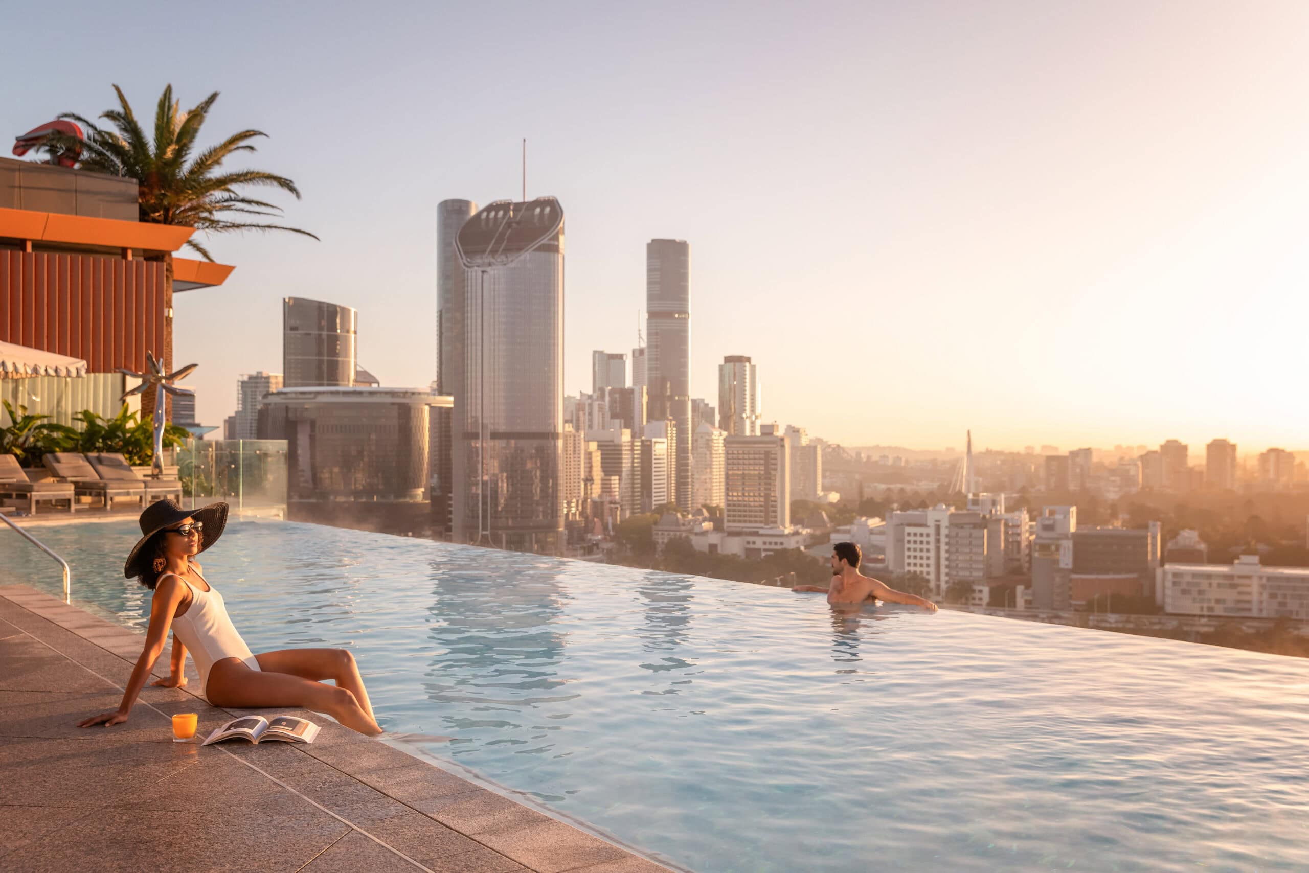 A woman sitting by the rooftop pool at Emporium Hotel South Bank