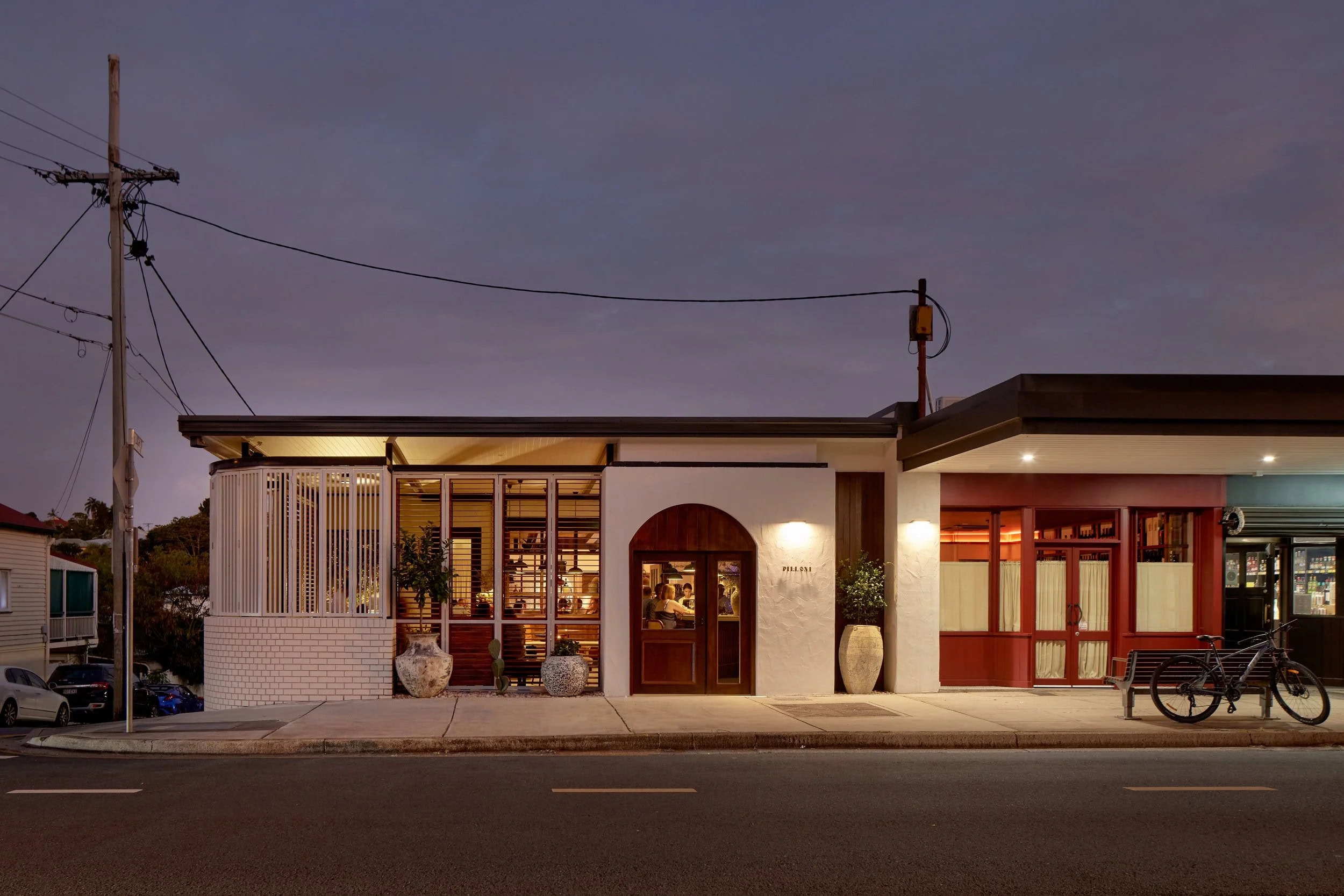 The exterior view of Pilloni restaurant in West End at twilight.