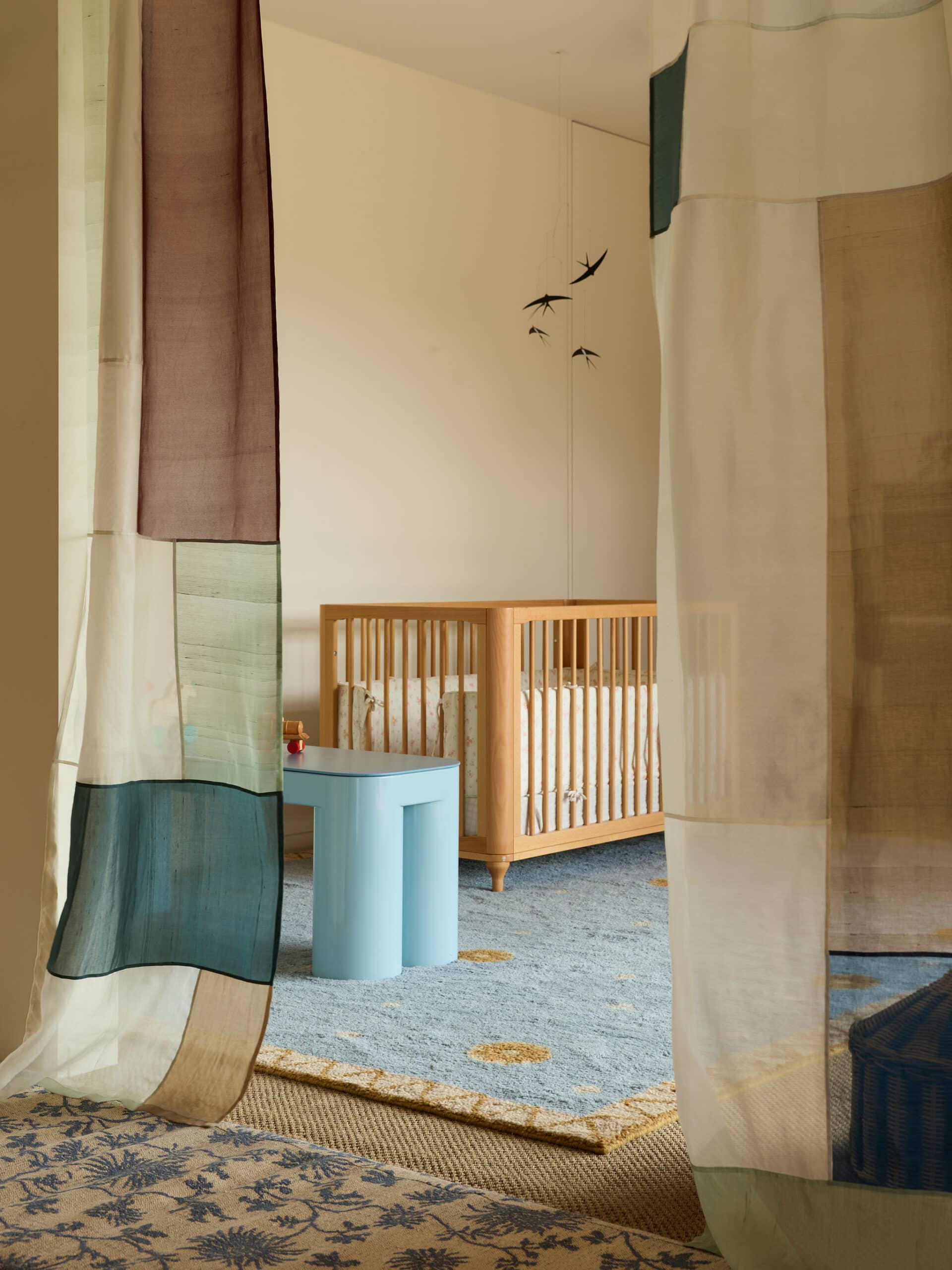 Constellation rug in Slate Blue by Olive Cooke x Double Studio in a nursery with a timber cot
