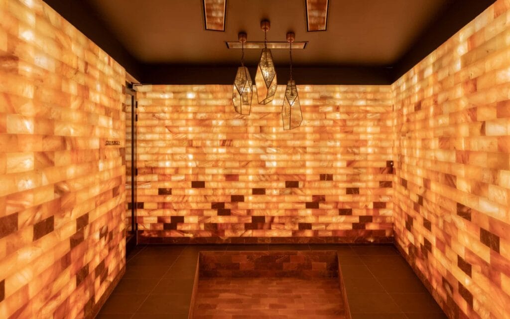 A spacious Himalayan salt cave room with hanging lanterns.