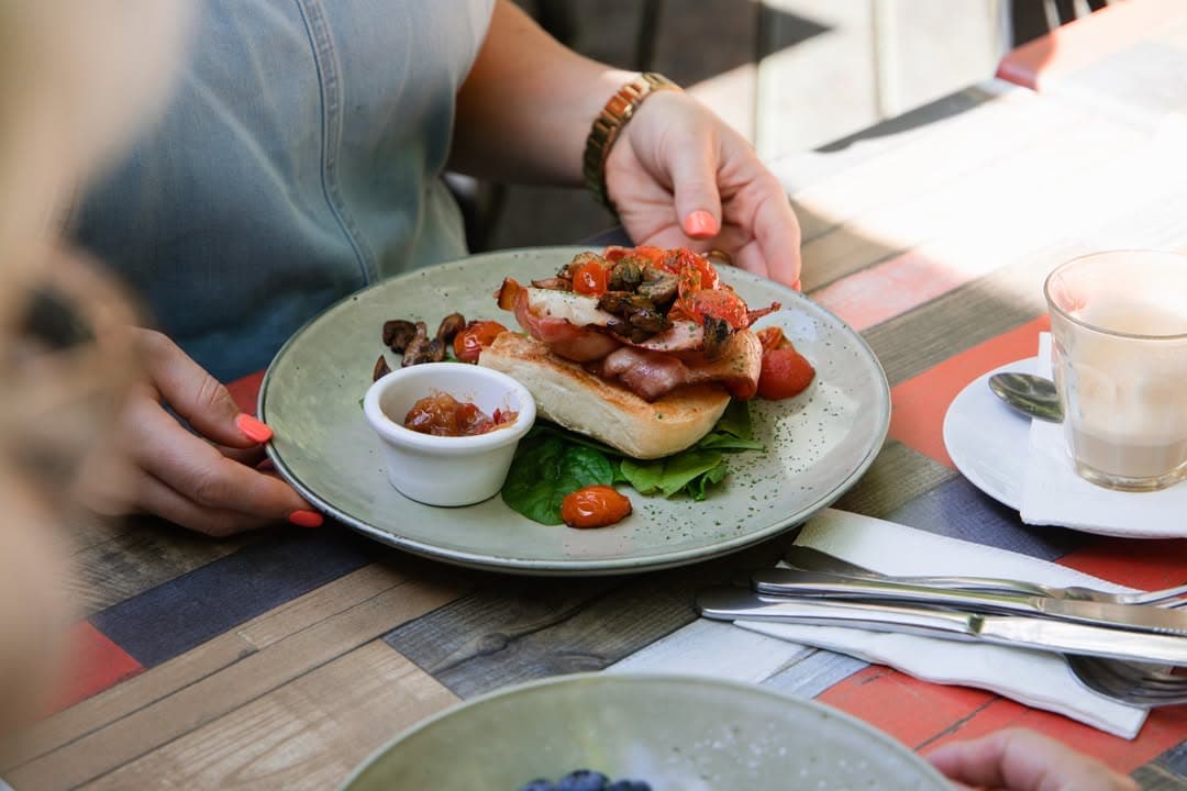 Someone receiving their breakfast order at the Rainforest Cafe in Port Macquarie.