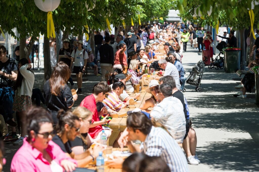 Diners seated at a long communal table at The Great Graze food festival Barangaroo Sydney