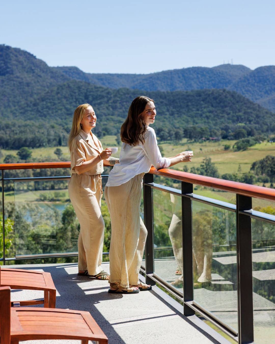 Two women on the balcony looking out over the view at Elysia Wellness Retreat in NSW.