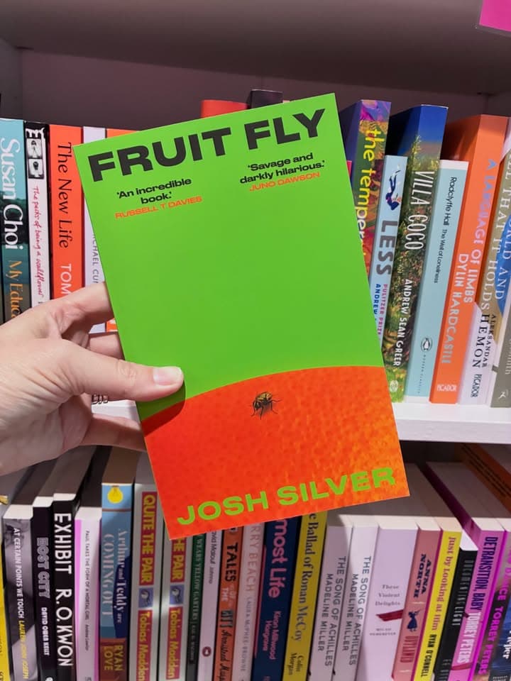 Someone holding up a copy of Fruit Fly the book at Shelf Lovers in Brisbane