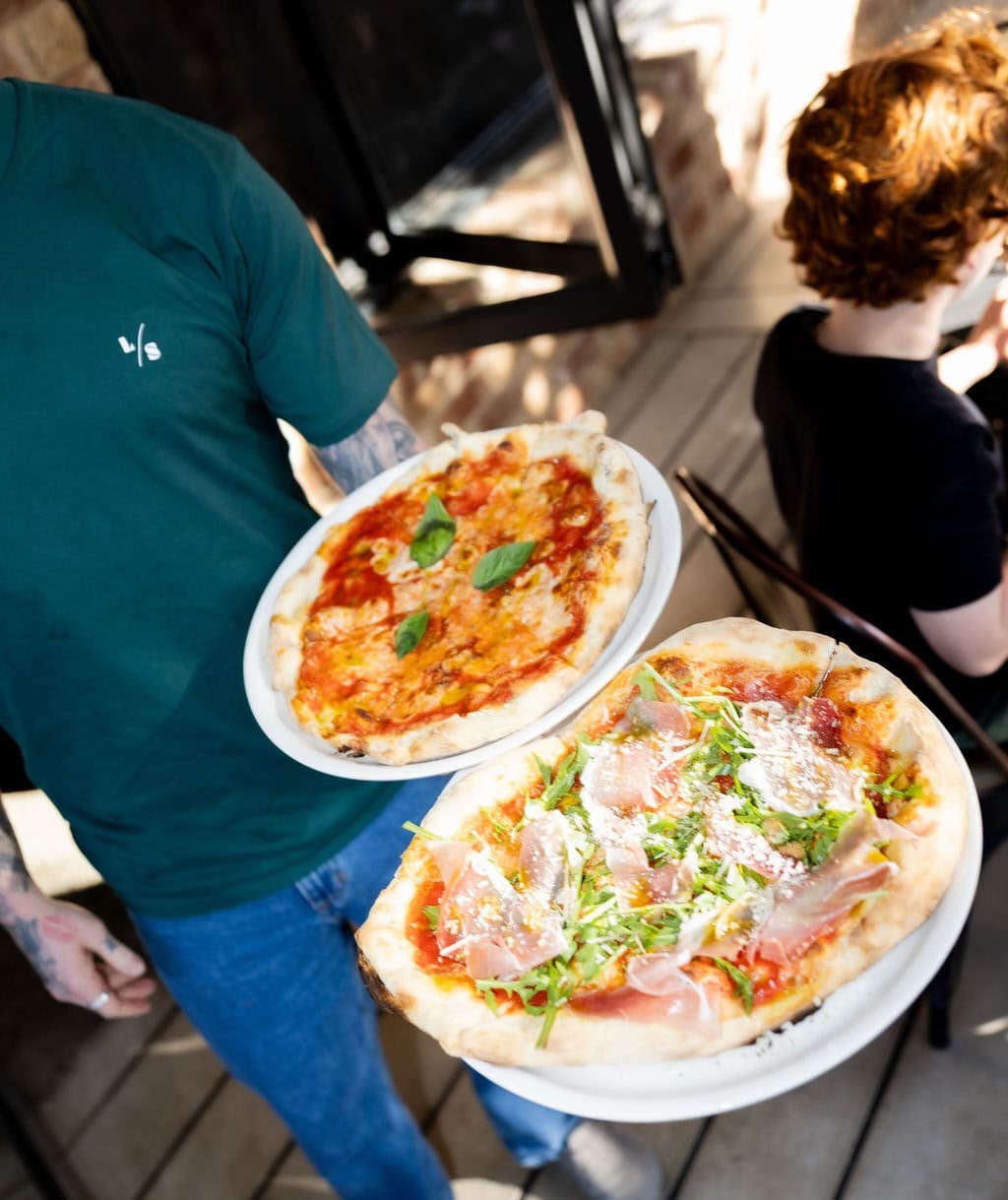 Sourdough margherita and prosciutto rocket pizzas served at a Little Sutton Bakehouse pizza night, Sutton and Deakin Canberra