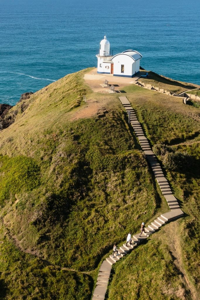 Aerial view of people walking up pathway leading to Tacking Point lighthouse in Port Macquarie.