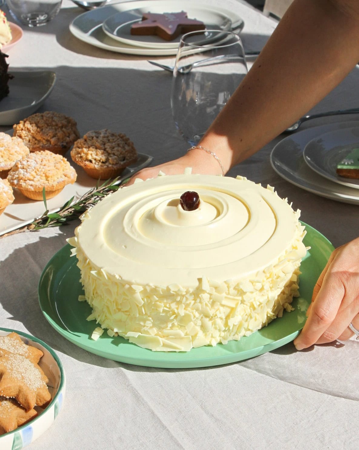 Someone placing down a white forest cake on a table from Jocelyn's Provisions in Brisbane.