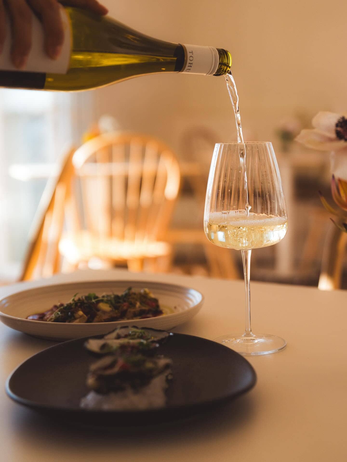 Someone pouring a glass of white wine at Banks in Port Macquarie.