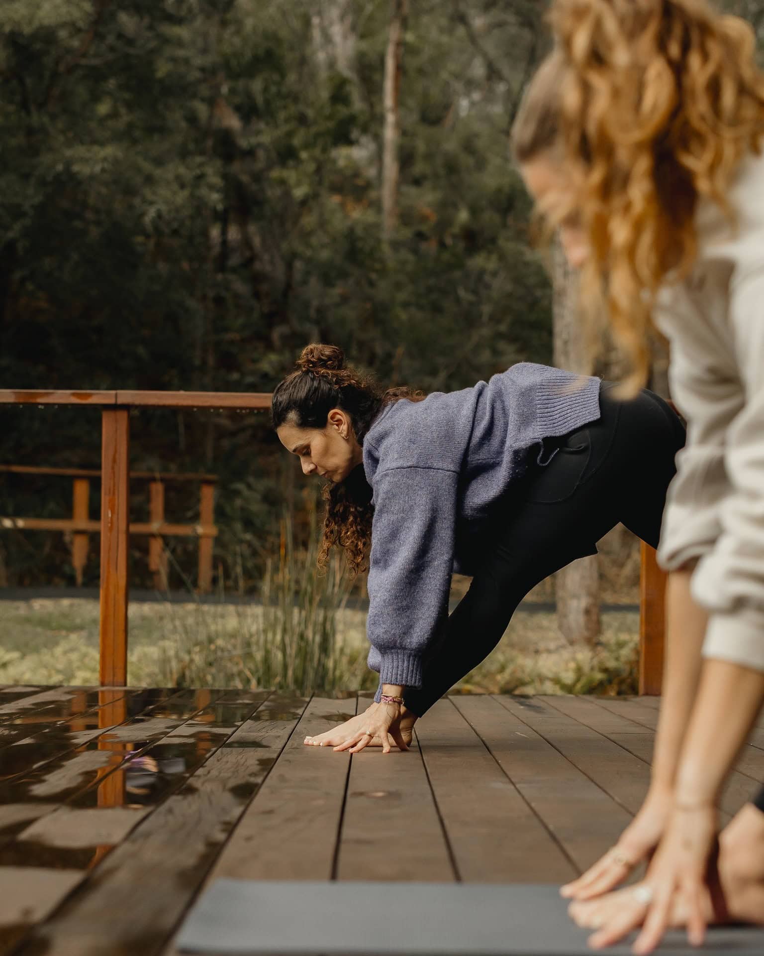 People engaging in a yoga class on the deck at Billabong Retreat.